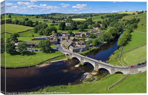 Burnsall Village and the river Wharfe. Canvas Print by Chris North