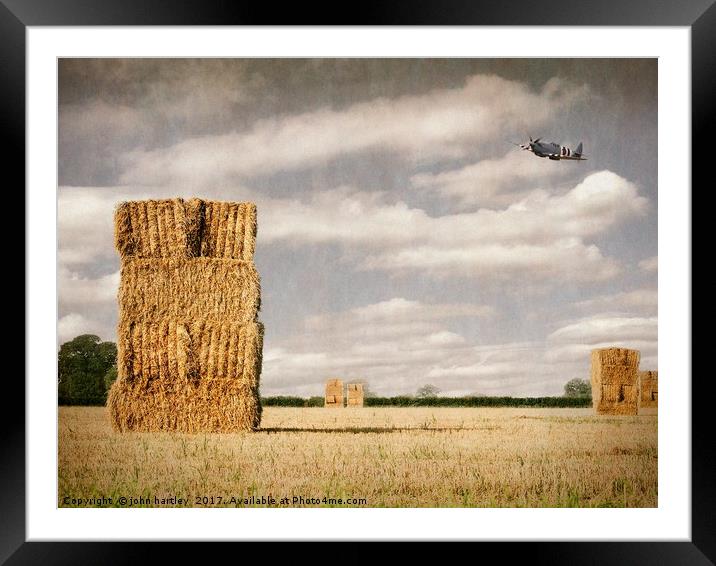  Spitfire at low level over a Cornfield with Hayst Framed Mounted Print by john hartley